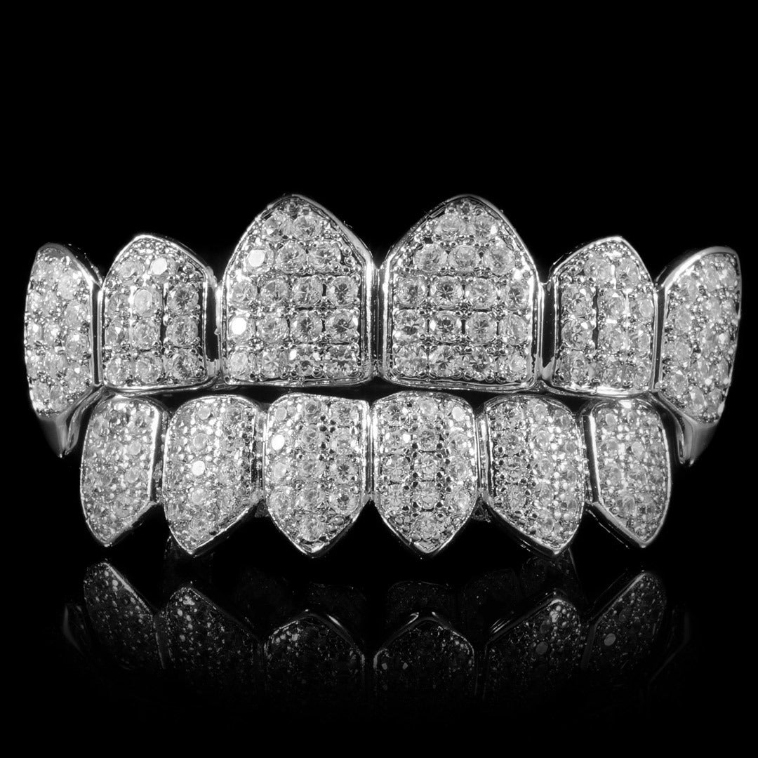 Front view of white gold plated CZ cluster grillz with pointed fangs, shown as a top and bottom set.